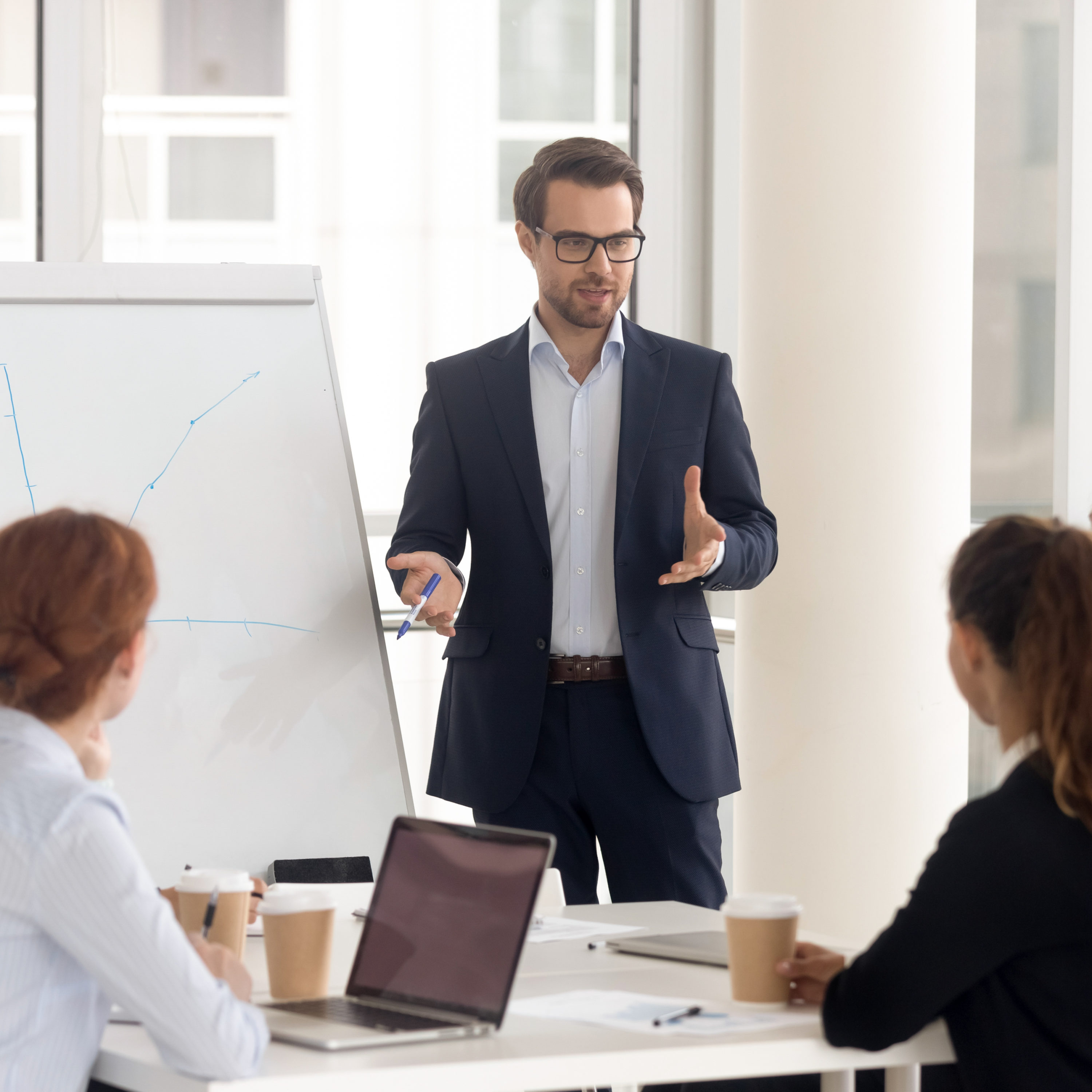 Male business coach speaker in suit give flipchart presentation