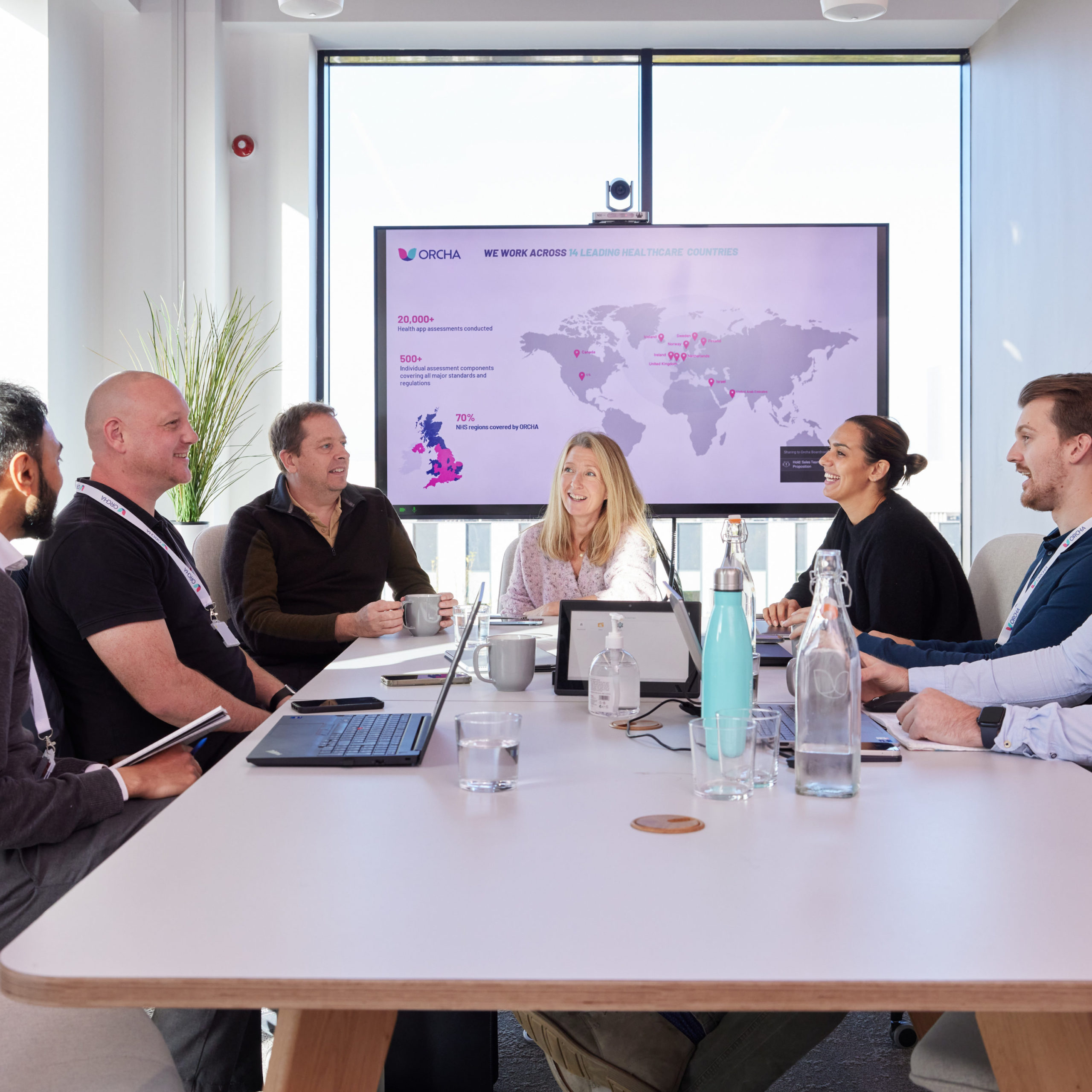 ORCHA Team sat around a boardroom table having a meeting