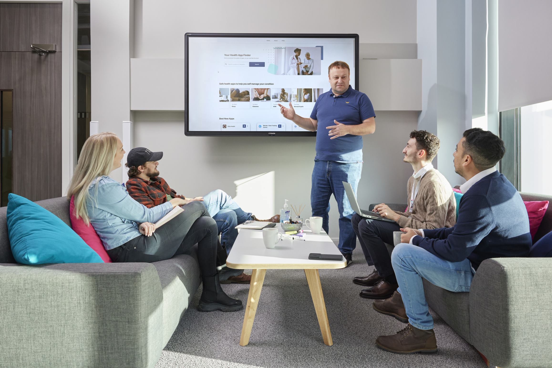 ORCHA development team looking at the ORCHA Health App Library on a big screen and brainstorming ideas.